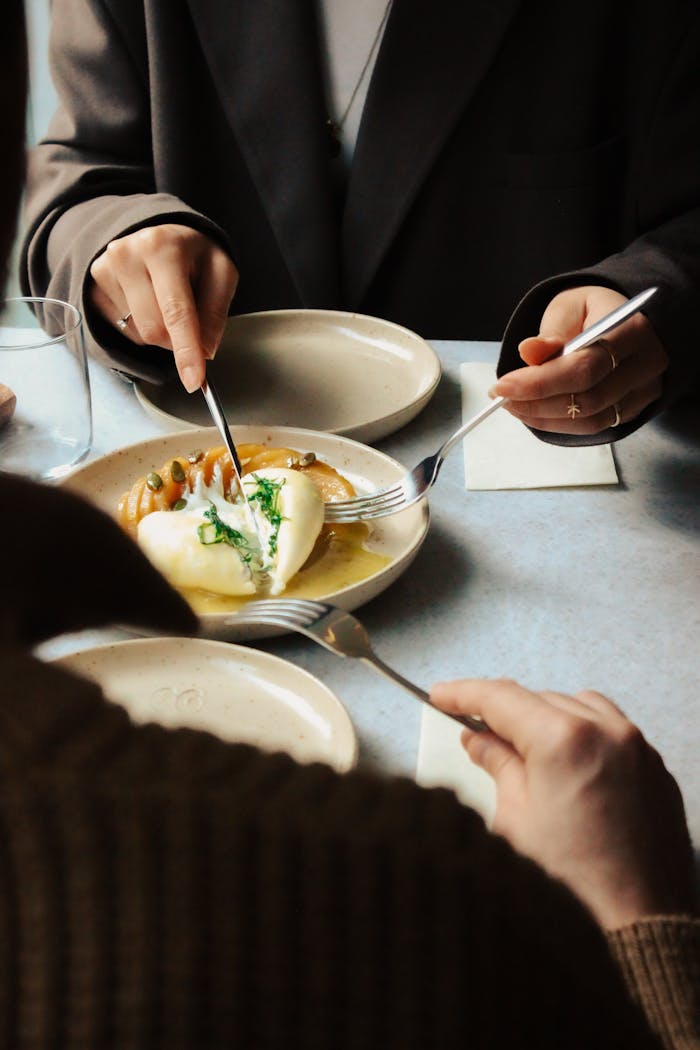 Crafting Captivating Headlines: Your awesome post title goes here Two adults enjoying a shared gourmet dish at a stylish cafe table with natural light.
